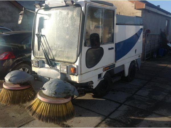 Mini road sweeper truck car sweeps vacuums and tips.